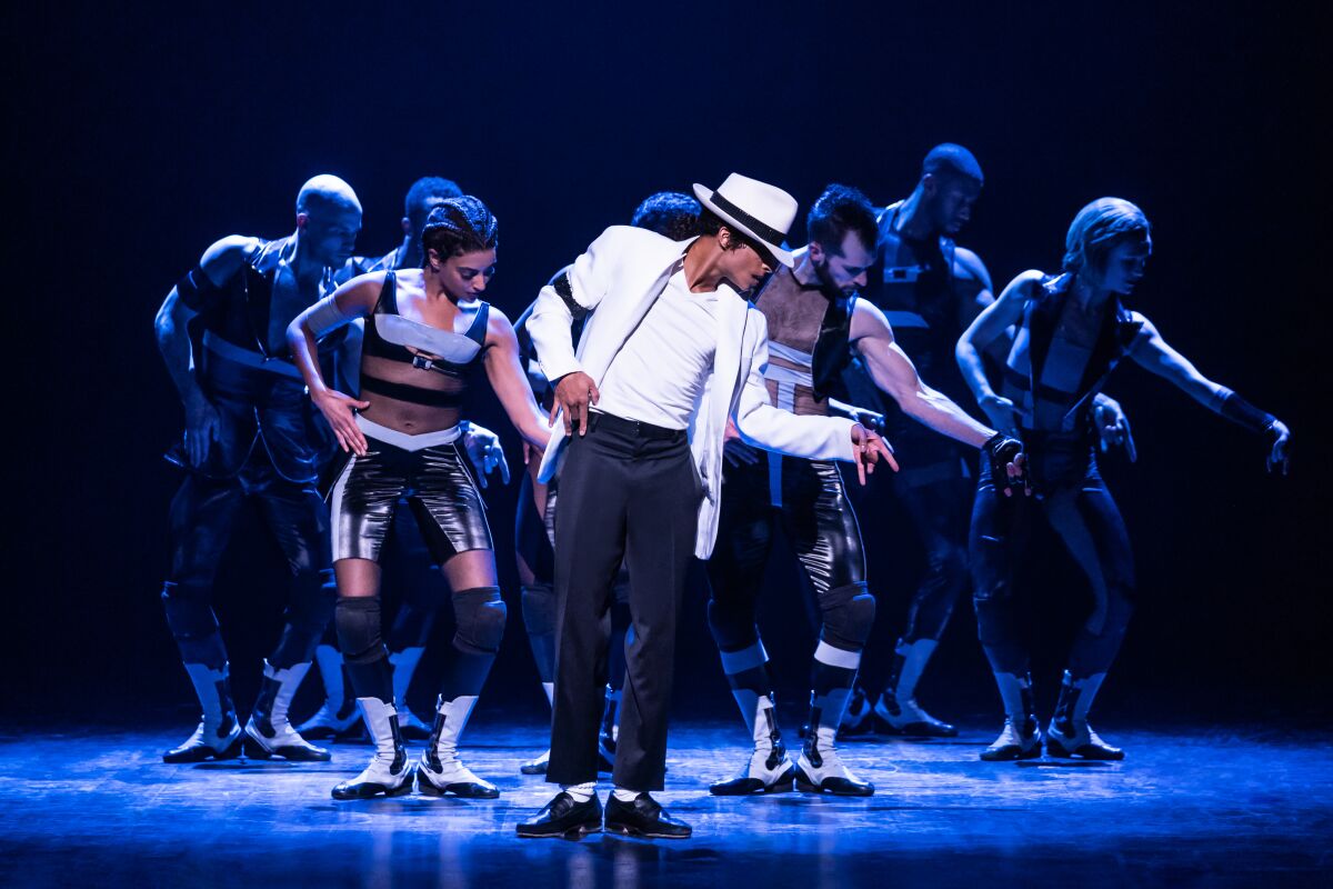 Actors dance in the style of Michael Jackson, led by a person dressed like Michael Jackson.