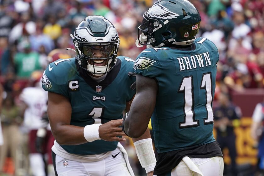 Philadelphia Eagles wide receiver A.J. Brown (11) and quarterback Jalen Hurts (1) celebrating their touchdown against the Washington Commanders during the first half of an NFL football game, Sunday, Sept. 25, 2022, in Landover, Md. (AP Photo/Alex Brandon)