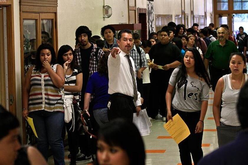 Students who have already received the whooping cough vaccine wait in line to submit proof of immunization Wednesday at Huntington Park High School. See full story