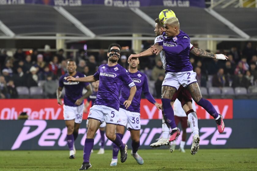 Fiorentina's Dodo, right, jumps to head the ball during the Italian Cup quarterfinal soccer match between Fiorentina and Torino at the Artemio Franchi stadium in Florence, Italy, Wednesday, Feb. 1, 2023. (Massimo Paolone/LaPresse via AP)