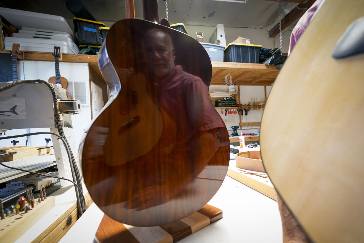 Luthier Shawn Weimar sees his reflection in one of the guitars he makes for his business, Zoe Guitars.