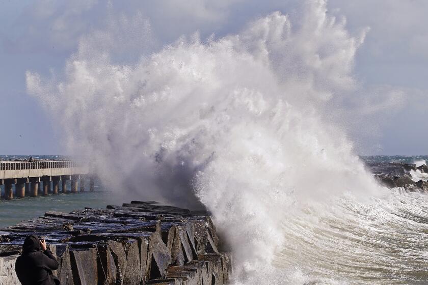SAN PEDRO, CALIF. - FEB. 22, 2023. A photographer captures a wave crashing into the breakwater at Cabrillo Beach in San Pedro on Wednesday, Feb. 22, 2023. More cold and wet weather, with high winds and surf, are forecast for Southern California as a Canadian cold front moves through the region this week. (Luis Sinco / Los Angeles Times)