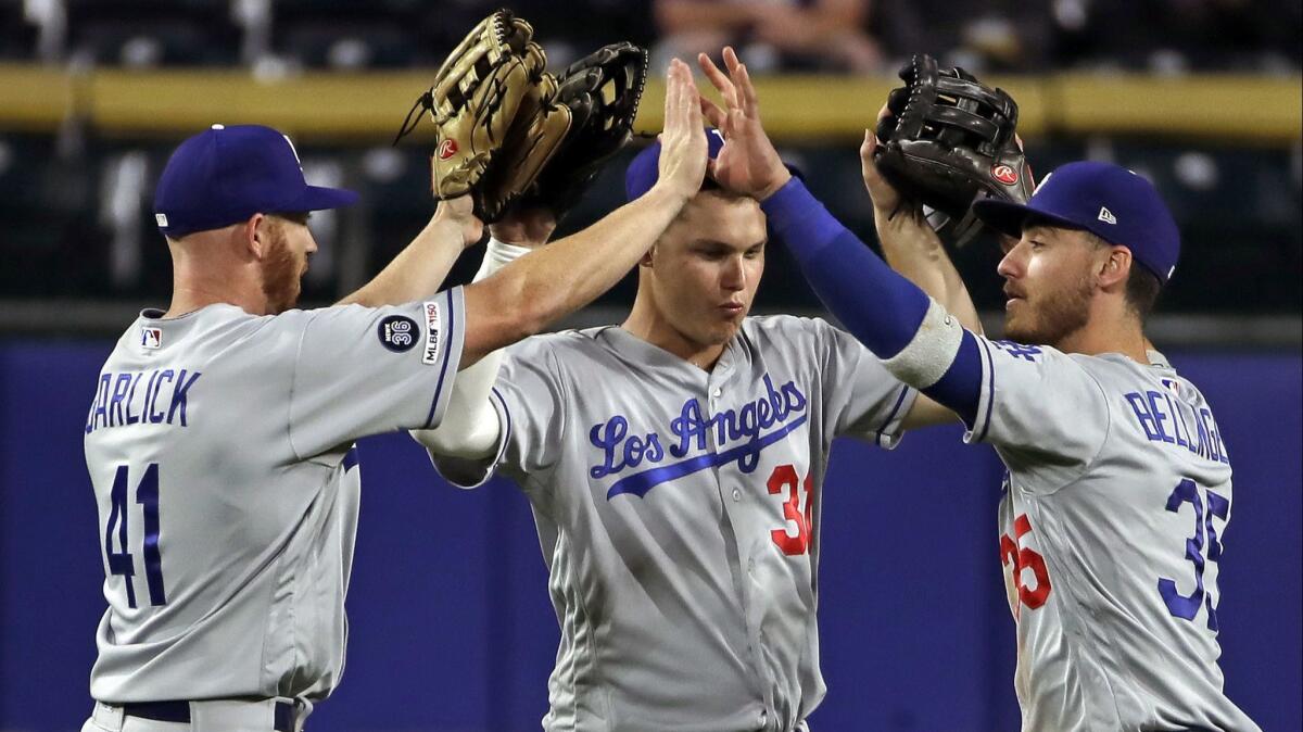 Dodgers outfielders (from left) Kyle Garlick, Joc Pederson and Cody Bellinger celebrate after the final out of a 7-2 win over the Pittsburgh Pirates on May 25.