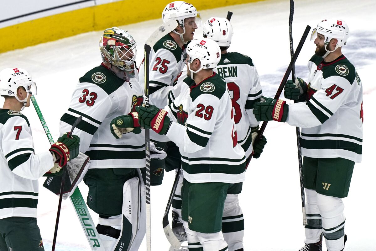 Minnesota Wild goaltender Cam Talbot (33) celebrates with teammates after the Wild defeated the Chicago Blackhawks 5-0 in an NHL hockey game in Chicago, Wednesday, Feb. 2, 2022. (AP Photo/Nam Y. Huh)