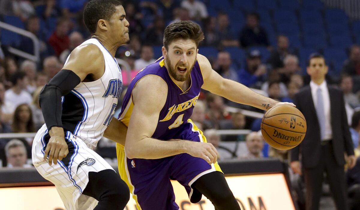 Lakers forward Ryan Kelly drives past Magic forward Tobias Harris in the first half.