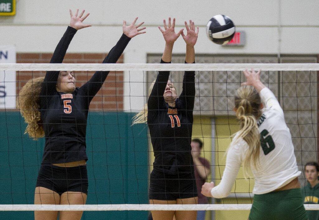 Huntington Beach's Mahina Williamson, left, and Cami Sanchez attempt to block a shot from Edison's Cassidy Dennison.