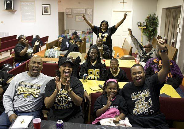 Rev. Billy Zacharie and congregants of the Jesus Outreach Ministries and Fellowship in New Orleans East, La., celebrate as their beloved New Orleans Saints score a field goal to end the first half of the Super Bowl.