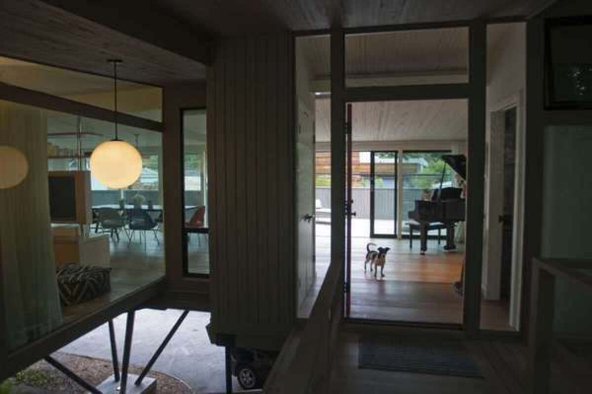The entrance to Molly Stanton's Santa Monica Canyon home looks much like it did when Rodney Walker designed it in 1956. The original door opens to a glass-walled open plan; at bottom left, steel posts create the effect of a floating hideaway.