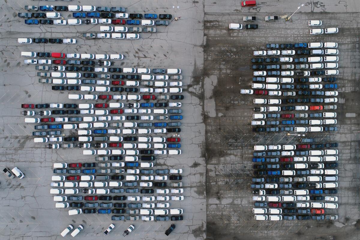 FILE - In this March 24, 2021 file photo, mid-sized pickup trucks and full-size vans are seen in a parking lot outside a General Motors assembly plant where they are produced in Wentzville, Mo. The global shortage of computer chips is getting worse, forcing automakers to temporarily close factories including those that build popular pickup trucks. General Motors announced Thursday, Sept, 2, 2021 that it would pause production at seven North American plants during the next two weeks, including two that make the company’s top-selling Chevrolet Silverado pickup. (AP Photo/Jeff Roberson, File)