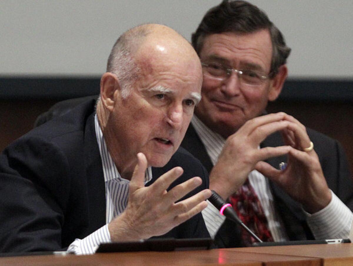 Gov. Jerry Brown, left, speaks as Chancellor Timothy P. White listens at a meeting of Cal State trustees in Long Beach.
