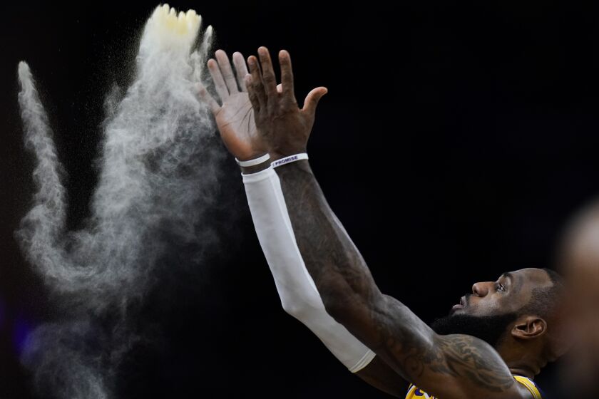 Los Angeles Lakers' LeBron James tosses powder before the team's NBA basketball game against the Dallas Mavericks on Thursday, Jan. 12, 2023, in Los Angeles. (AP Photo/Jae C. Hong)