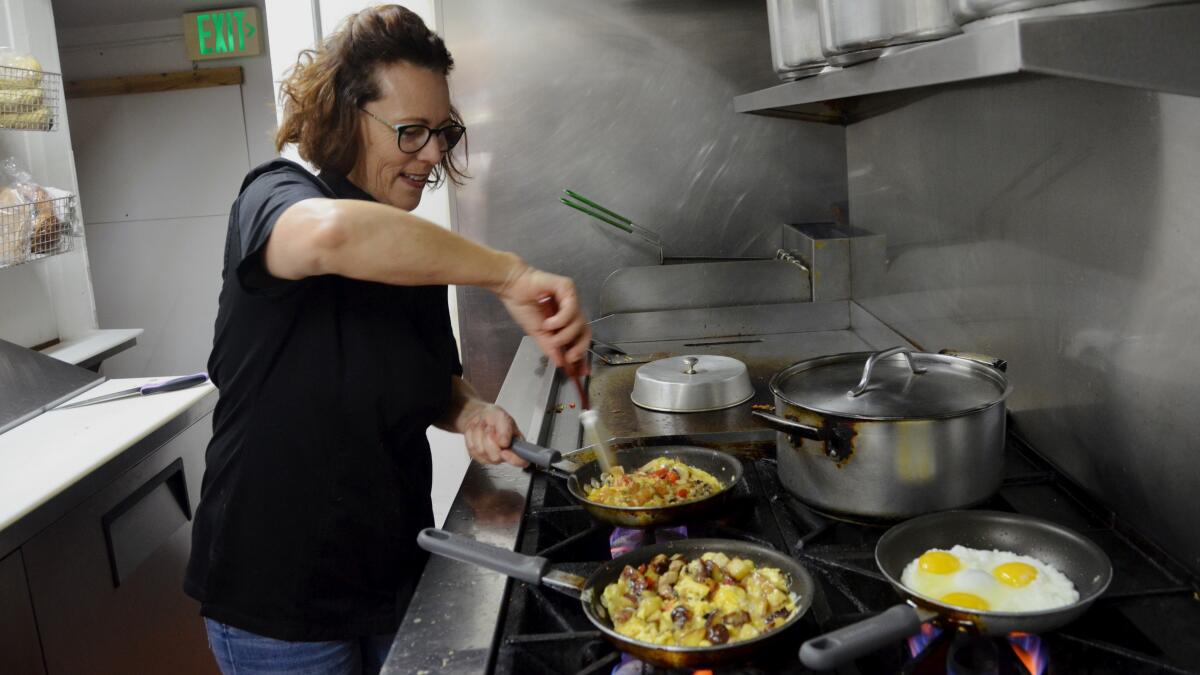 Victoria DeFrenza, who with her husband, John, owns Crocker's The Well-Dressed Frank and Abundant Table restaurants on Balboa Island, prepares egg dishes for breakfast customers.