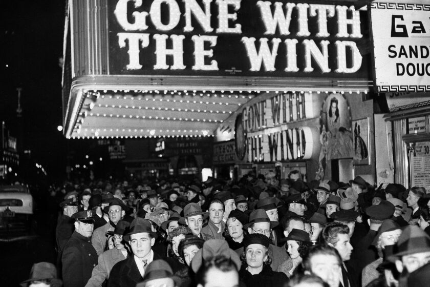 In this Dec. 19, 1939 file photo, a crowd walks past the Astor Theater during the Broadway premiere of "Gone With the Wind" in New York. A Memphis, Tennessee, theater has cancelled an annual screening of the classic 1939 film because of racially insensitive content.