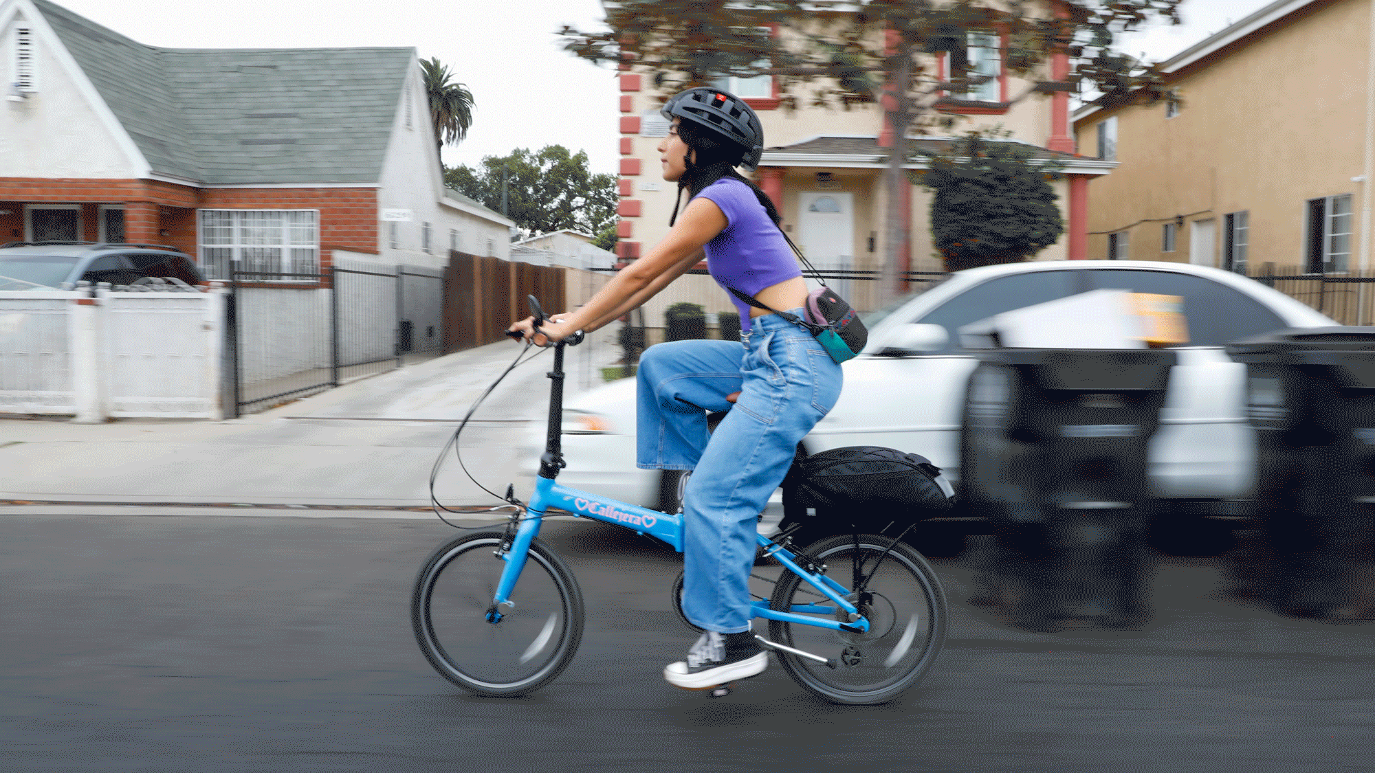 A looping boomerang GIF of Michelle Moro riding her blue bicycle in a neighborhood.