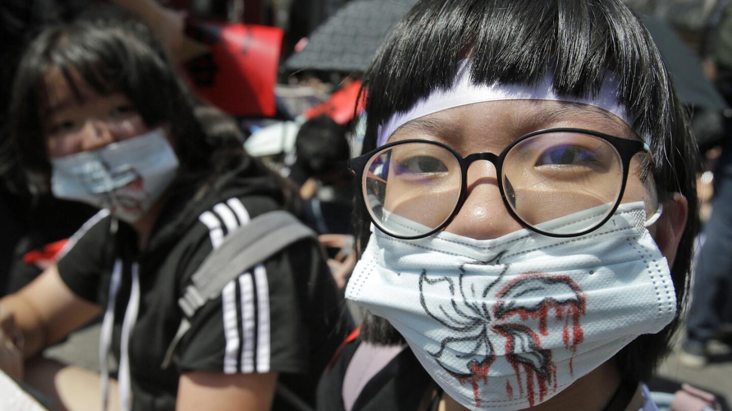 Hong Kong protest supporters in Taipei, Taiwan, wear masks depicting bloody flowers.