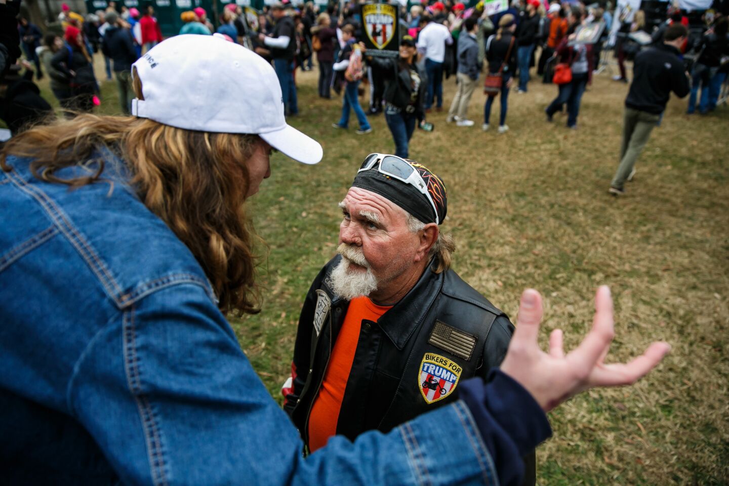 Julia Hook, left, debates to R.C. Pittman, member of Bikers for Trump, as they discuss political views and values. At the end of the conversation they agreed on one thing: a peaceful protest and coming together to reason.