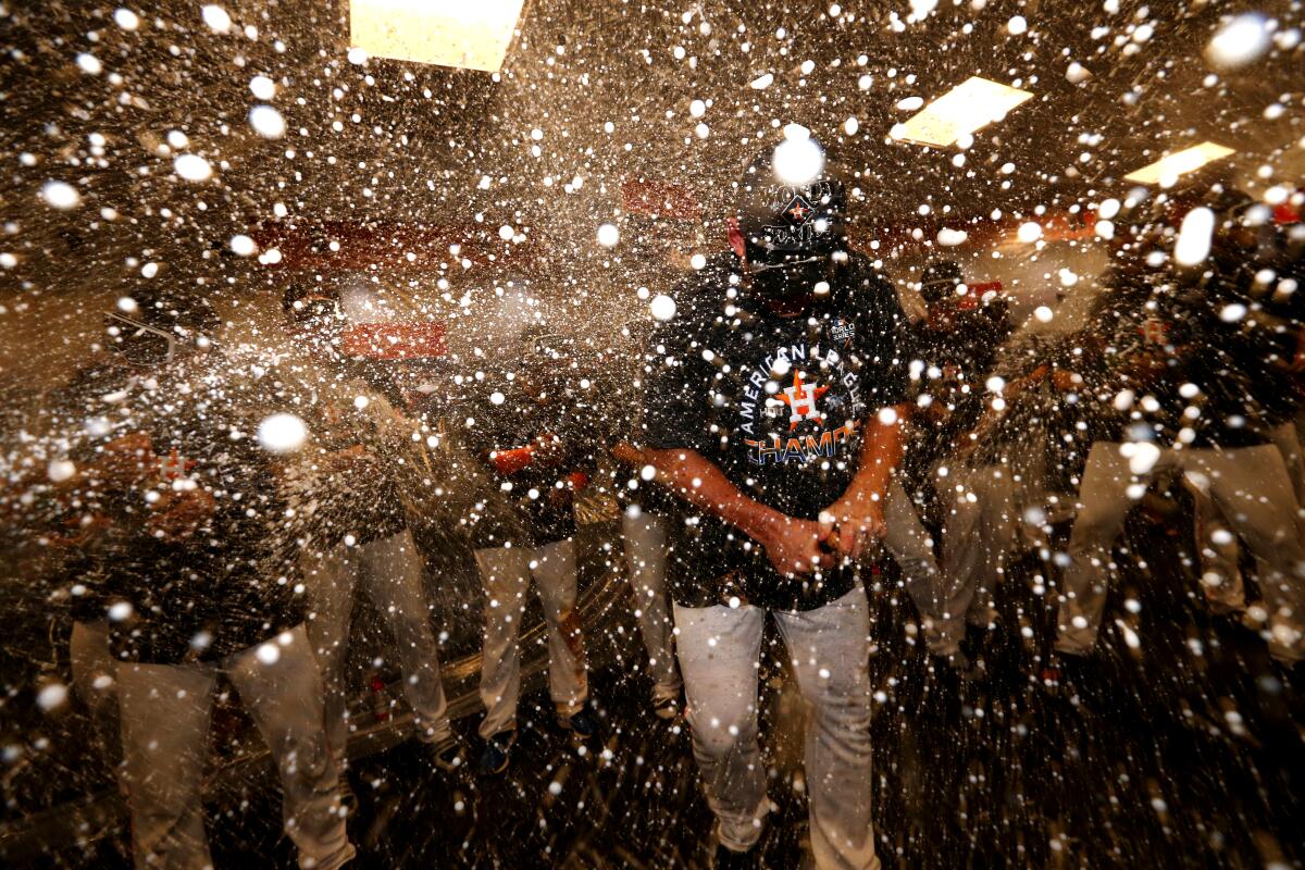 The Houston Astros celebrate in the locker room after clinching the American League pennant with a 6-4 win over the New York Yankees on Oct. 19.