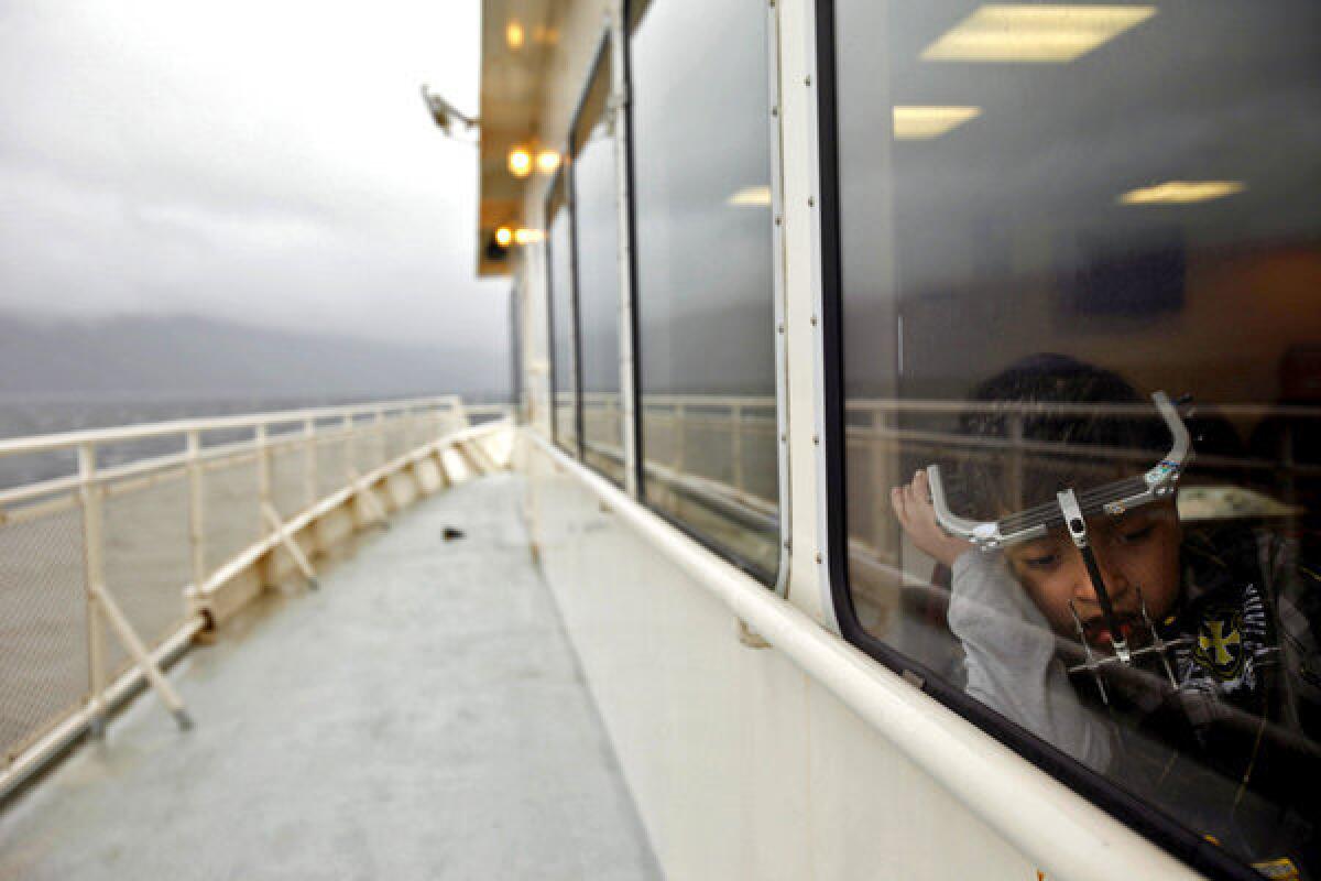 James Weatherwax, 11, spends a quiet moment during a 3 1/2-hour ferry ride from Hollis to Ketchikan in Alaska. From there, he and his mother, Kecia, will take a plane to Seattle, where James will have his halo removed at Children's Hospital.
