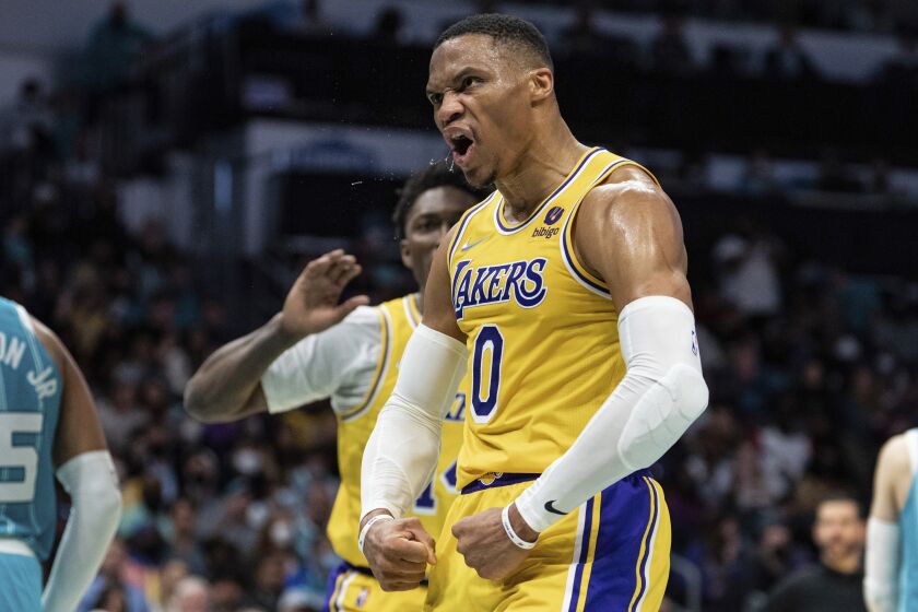 Los Angeles Lakers guard Russell Westbrook (0) celebrates with forward Stanley Johnson, behind, during the second half of an NBA basketball game against the Charlotte Hornets in Charlotte, N.C., Friday, Jan. 28, 2022. (AP Photo/Jacob Kupferman)
