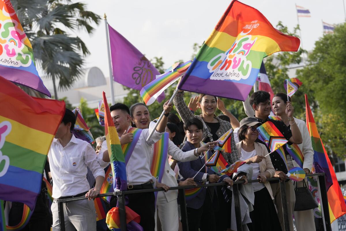 Participants waving flags celebrating equality in marriage in Bangkok