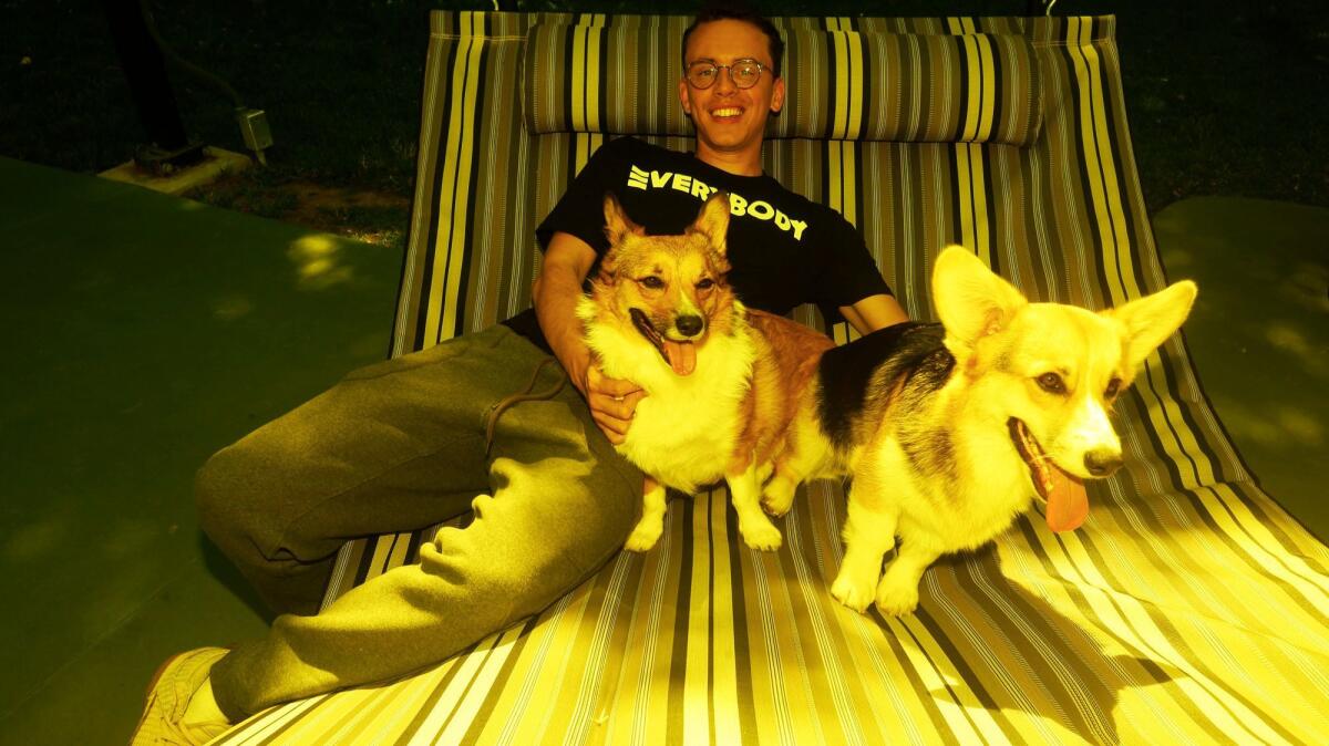 Logic relaxes with his dogs -- Fry, left, and Panda at -- his home in Tarzana.