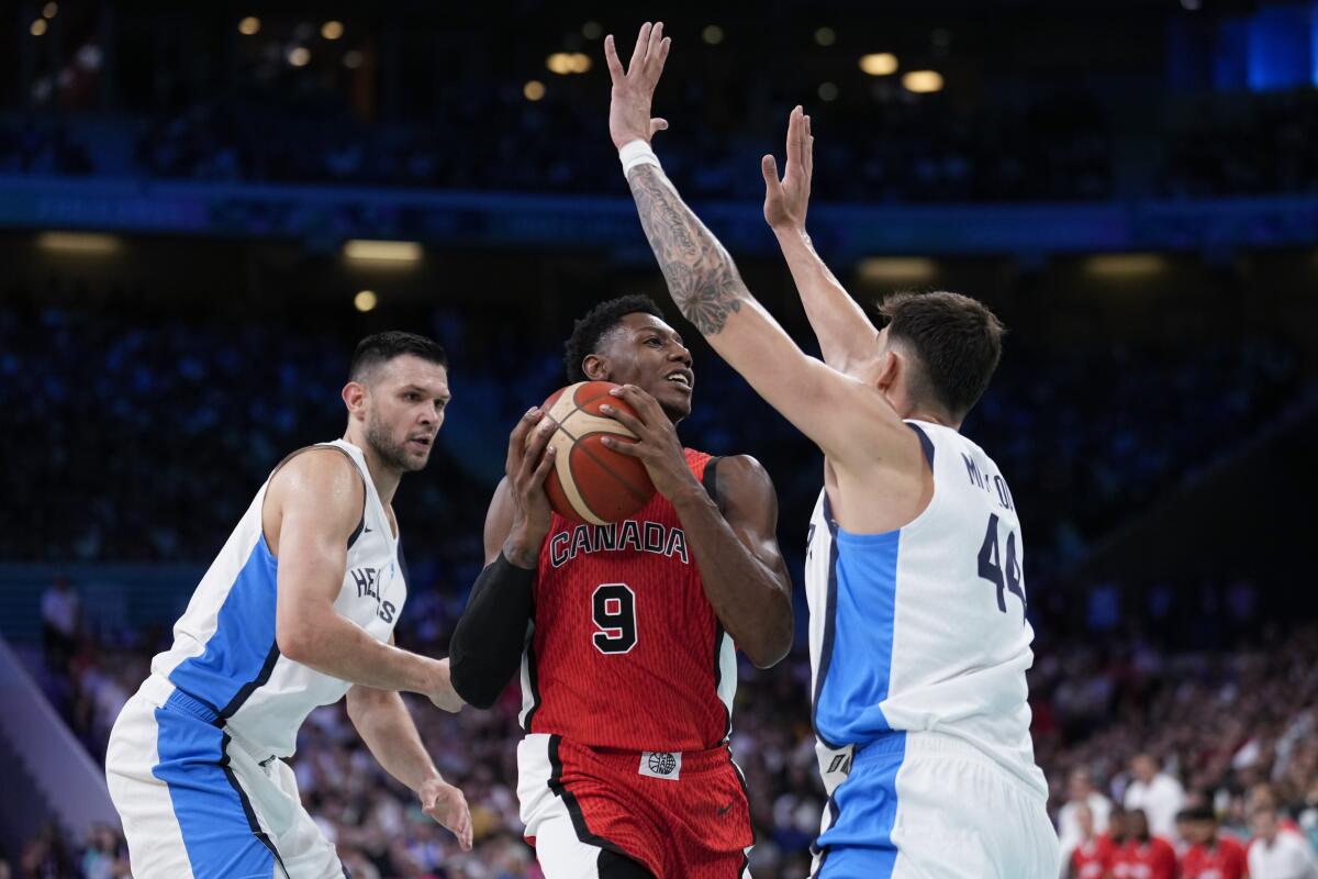 RJ Barrett, of Canada, is stopped by Dinos Mitoglou, of Greece, as he tries to shoot during a game Saturday 
