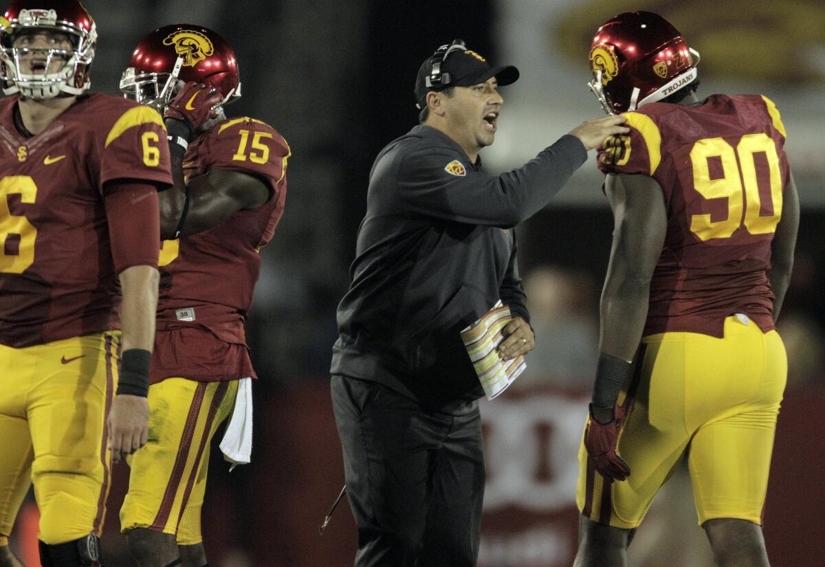 Trojans Coach Steve Sarkisian gives defensive tackle Claude Pelon a pat on the shoulder after a defensive stop in the first half against Cal.