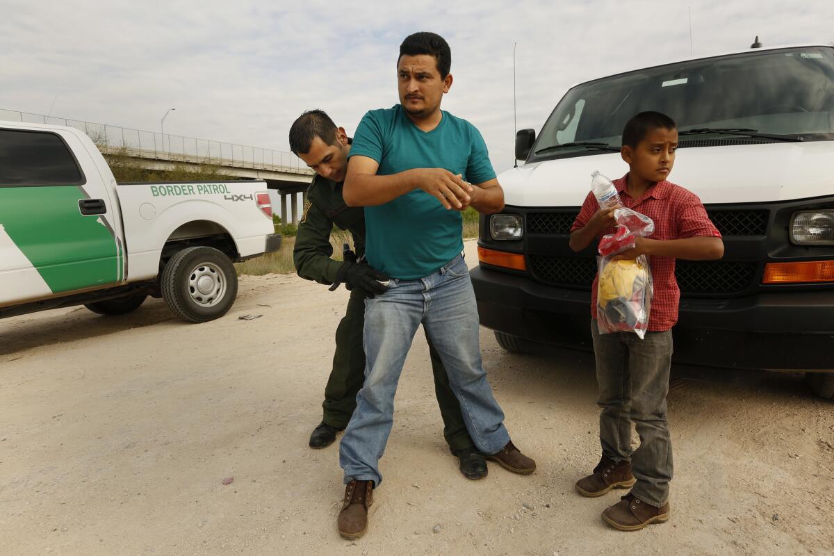 David Martinez, 31, and his 11-year-old son are detained by Border Patrol Agent Robert Rodriguez.