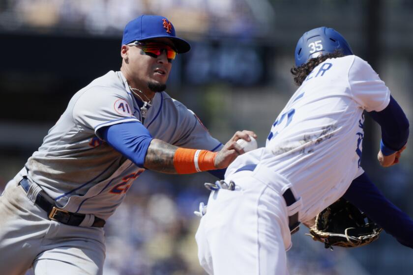 New York Mets shortstop Javier Baez, left, tags out Los Angeles Dodgers' Cody Bellinger on a steal-attempt during the fourth inning of a baseball game in Los Angeles, Sunday, Aug. 22, 2021. (AP Photo/Alex Gallardo)