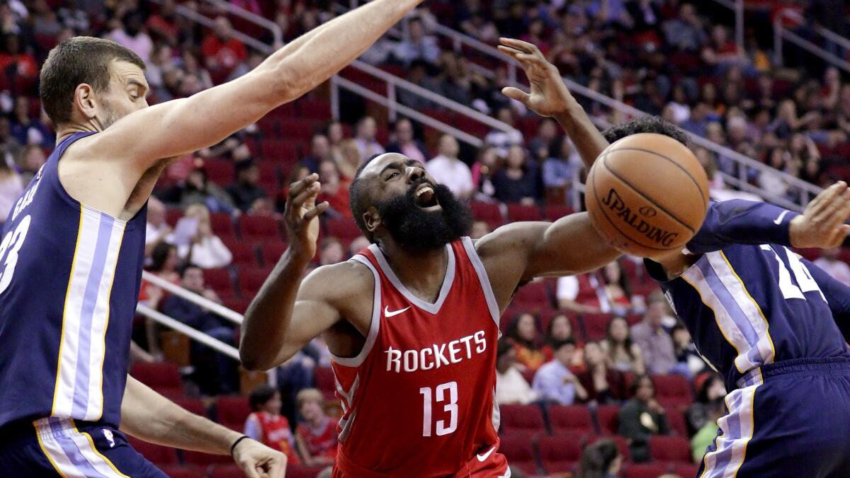 Rockets guard James Harden loses control of the ball on a drive to the basket between Grizzlies center Marc Gasol, left, and forward Dillon Brooks during the second half Saturday.