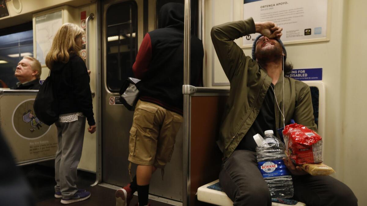 John Fuller, right, talks to himself while riding the Red Line. (Francine Orr / Los Angeles Times)