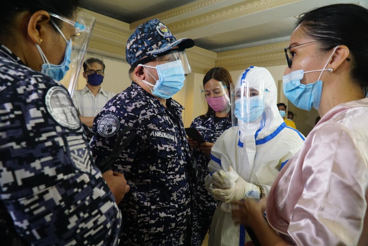 Reina Mae Nasino, in hazmat suit and handcuffs, is surrounded by prison guards at her daughter's wake.