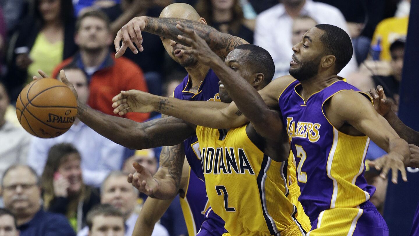 Indiana Pacers guard Rodney Stuckey, center, battles Lakers guard Wayne Ellington, right, and center Robert Sacre for a loose ball during the first half of the Lakers' loss on Dec. 15.