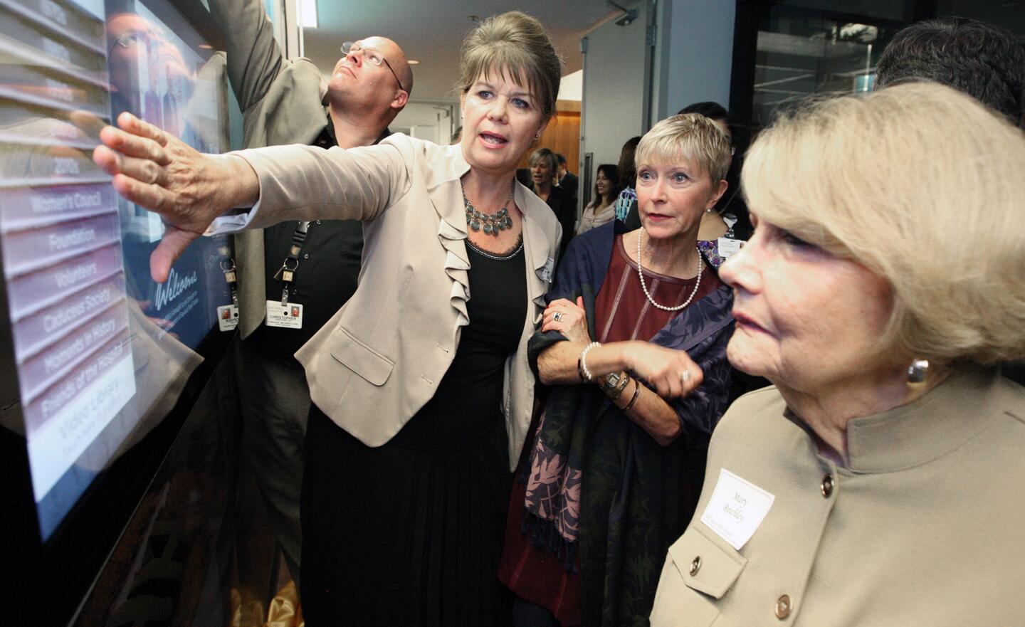 Theresa Robbins of Axcess Video shows off the interface of the Verdugo HIlls Hospital's history wall to Sue Wilder and Mary Reichley at the unveiling on Tuesday, March 31, 2015.