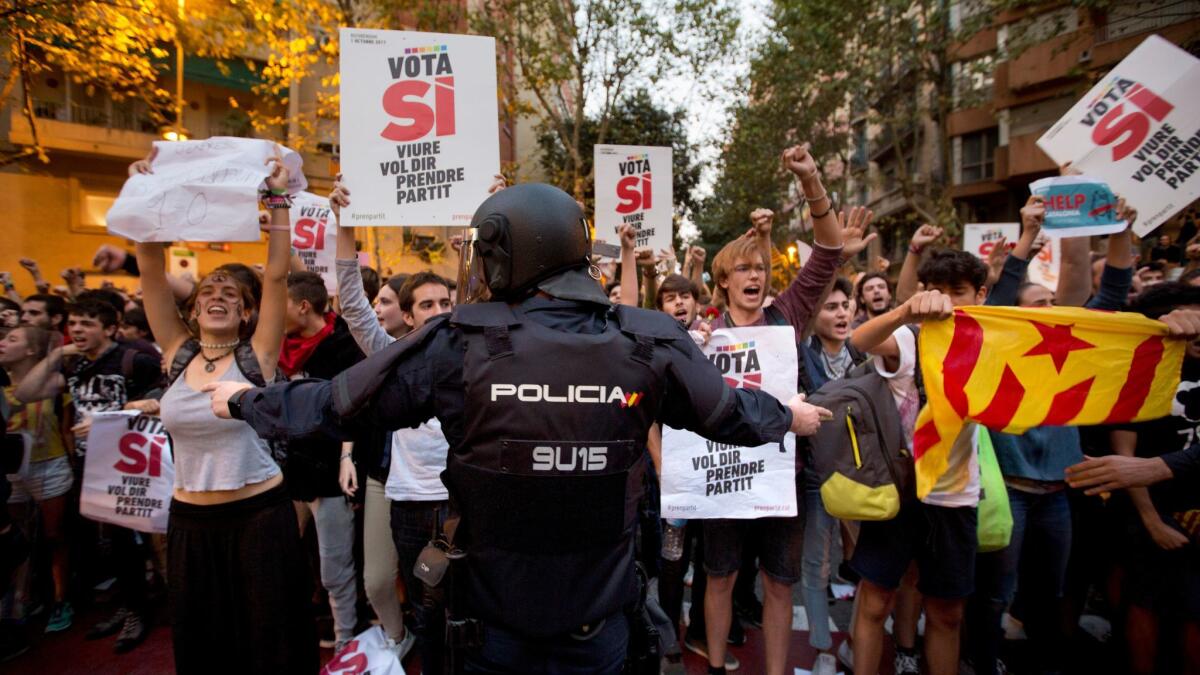A Spanish police officer tries to stop demonstrators protesting in Barcelona on Sept. 20, 2017.
