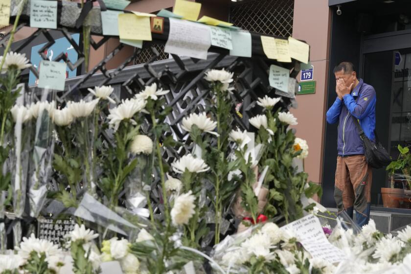 A man weeps as he pays tribute to victims of a deadly accident following Saturday night's Halloween festivities on a street near the scene in Seoul, South Korea, Tuesday, Nov. 1, 2022. South Korean police investigated on Monday what caused a crowd surge that killed more than 150 people during Halloween festivities in Seoul in the country’s worst disaster in years. (AP Photo/Ahn Young-joon)