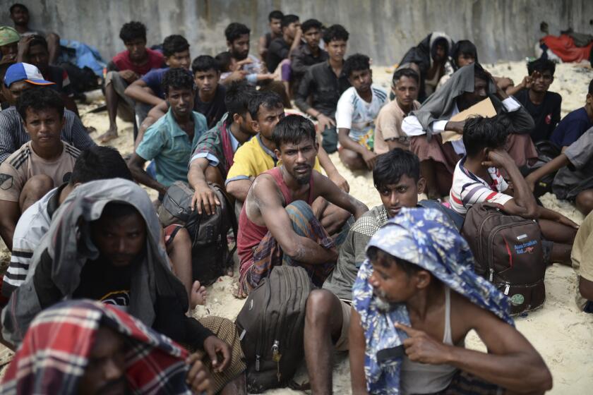 FILE - Ethnic Rohingya men sit on a beach after they landed in Sabang, Aceh province, Indonesia, Wednesday, Nov. 22, 2023. The U.N. refugee agency on Monday Dec. 4, 2023 sounded the alarm for hundreds of Rohingya Muslims believed to be aboard two boats reported to be out of supplies and adrift on the Andaman Sea. (AP Photo/Reza Saifullah, File)