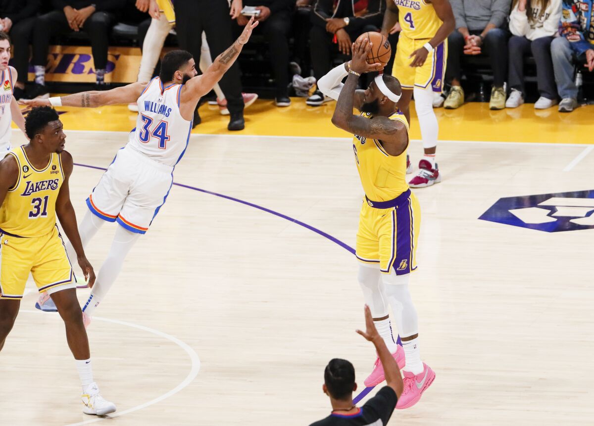 Lakers forward LeBron James shoots a three-pointer over Thunder forward Kenrich Williams.