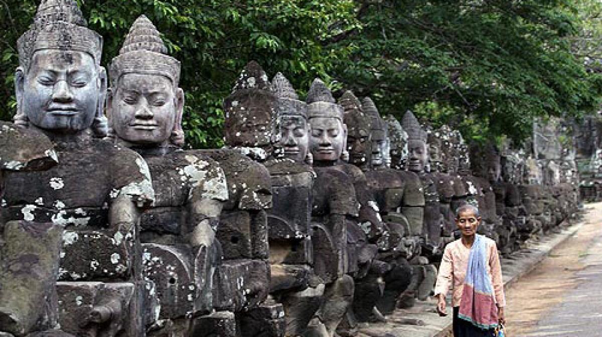 Statues line a roadway in the Angkor temple complex in Cambodia.
