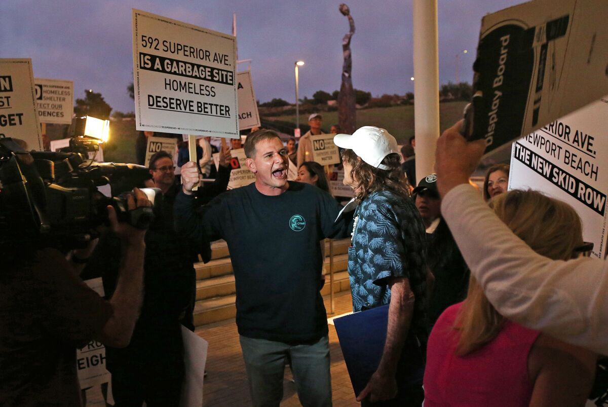 Residents chant and picket outside Newport Beach City Hall on Tuesday evening to voice their disapproval of a proposed homeless shelter at 592 Superior Ave.