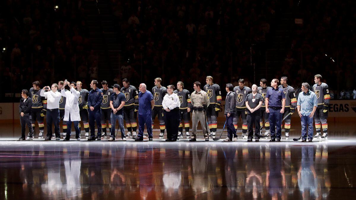 First responders stand with Vegas Golden Knights players during a ceremony to honor the first responders of the shooting in Las Vegas before the game on Tuesday.