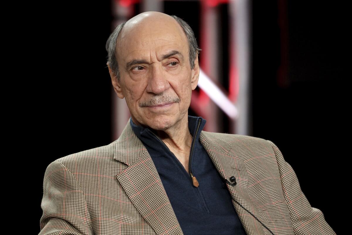 F. Murray Abraham looks to the side while wearing a brown blazer and black shirt