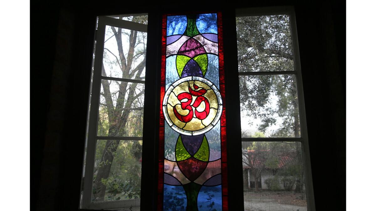 A stained-glass window displays a colorful Om symbol in the lecture hall at the Trabuco Canyon Monastery.