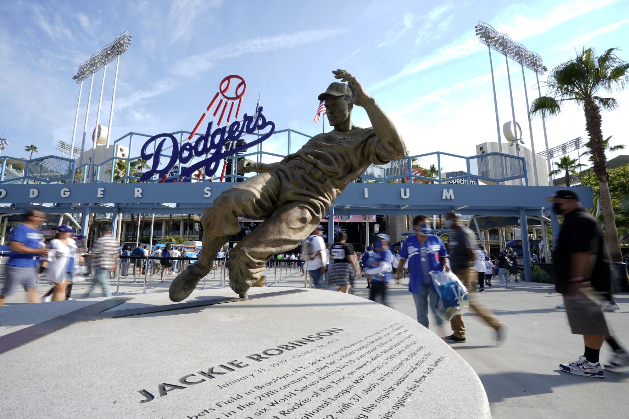 Fans walk by a statue of Jackie Robinson as they enter Dodger Stadium.