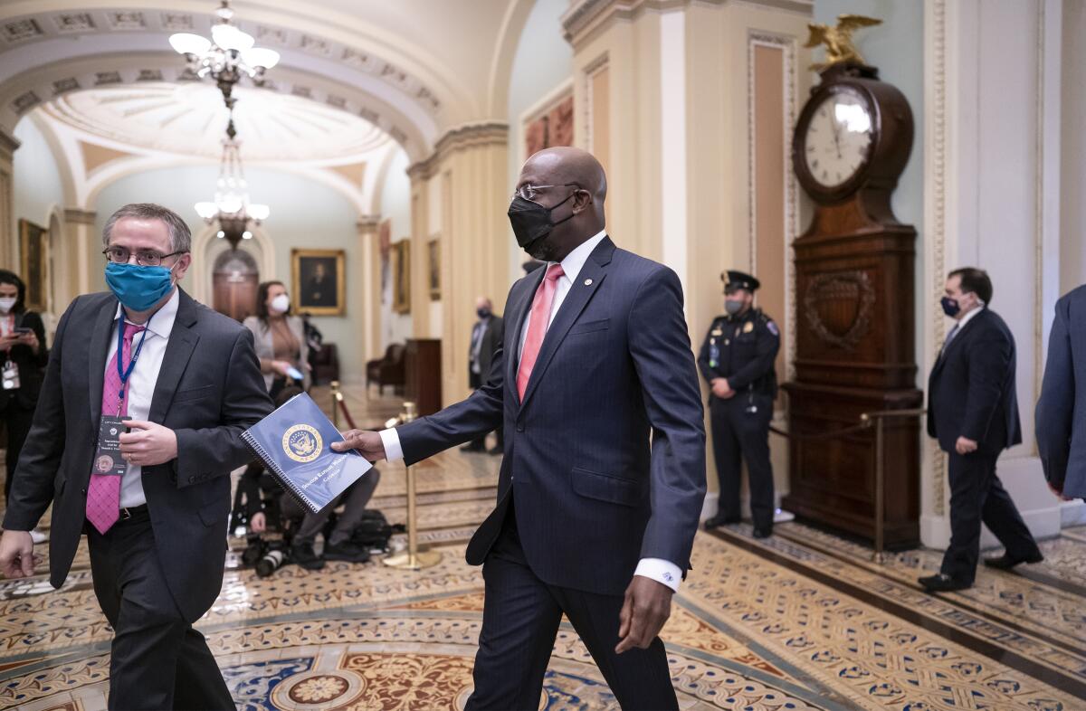 Sen. Raphael Warnock (D-Ga.) walks through the U.S. Capitol in February.