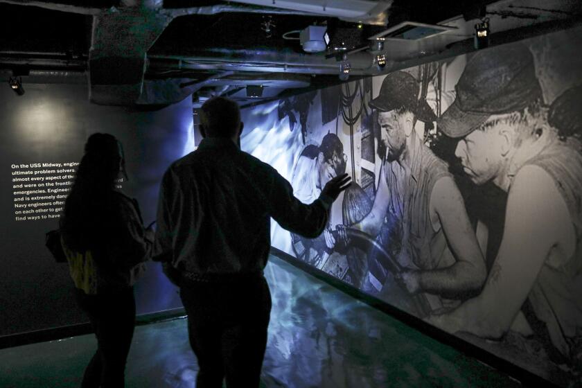 Guests walk through the USS Midway's new exhibit "Midway's Engineers:Service, Sacrifice and Everyday Life". on Saturday, May 25, 2024 aboar the ship in Downtown San Diego The immersive exhibition is focused on telling the stories of the aircraft carrier's hardworking engineers.(Photo by Sandy Huffaker for The SD Union-Tribune)