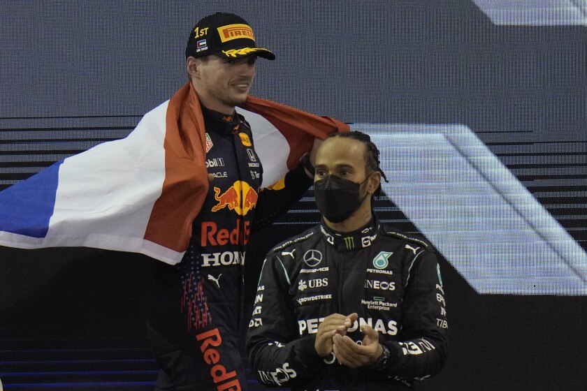 FILE - Red Bull driver Max Verstappen of the Netherlands celebrates after becoming the world champion after winning the Formula One Abu Dhabi Grand Prix in Abu Dhabi, UAE, Sunday, Dec. 12, 2021. Mercedes driver Lewis Hamilton of Britain stands in foreground. Formula One’s former race director Michael Masi has revealed the shocking abuse he received on social media following last season’s controversial call at the season-ending the Abu Dhabi Grand Prix. Max Verstappen won his first world title after overtaking Lewis Hamilton on the last lap following a controversial restart procedure. (AP Photo/Hassan Ammar, File)