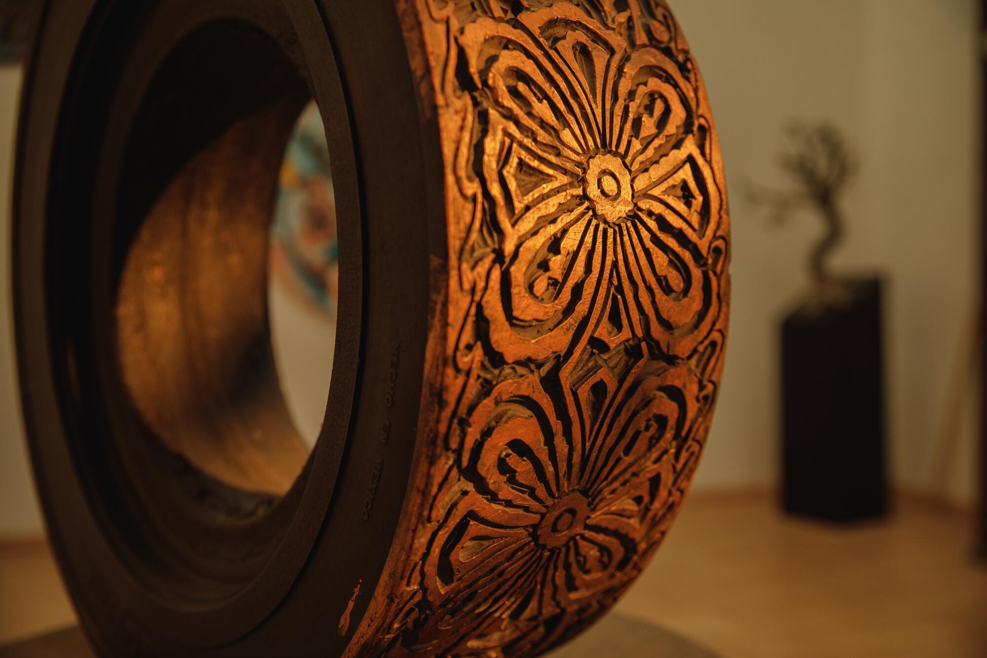 Detail of a vehicle tire that has been carved and painted into sculpture. 