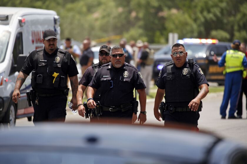 FILE — Police walk near Robb Elementary School following a shooting, May 24, 2022, in Uvalde, Texas. Four months after the Robb Elementary School shooting, the Uvalde school district on Friday, Oct. 7 pulled its entire embattled campus police force off the job following a wave of new outrage over the hiring of a former Texas state trooper who was part of the hesitant law enforcement response as a gunman killed 19 children and two teachers. (AP Photo/Dario Lopez-Mills, File)