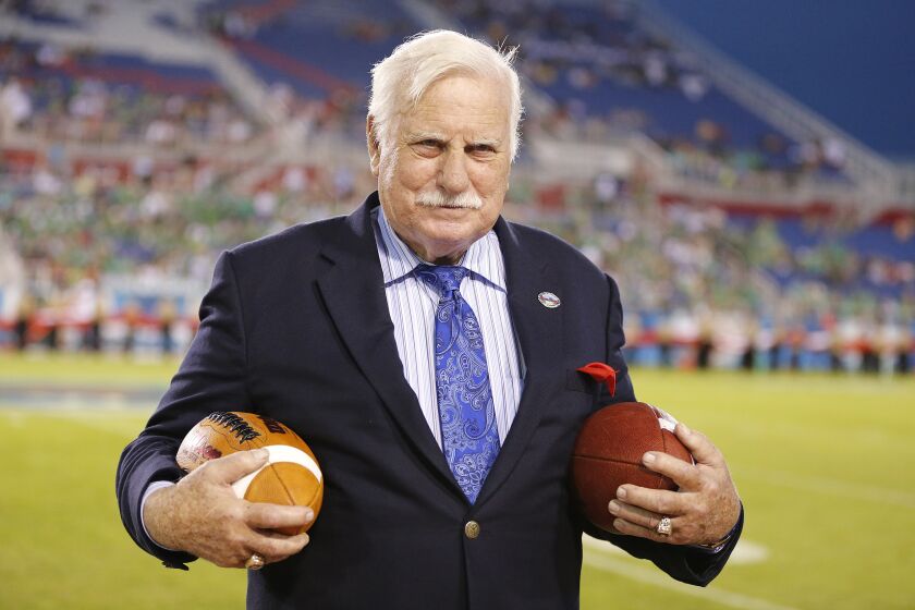 In this Dec. 23, 2014 photo, former Florida Atlantic and Miami head coach, Howard Schnellenberger holds the game balls.
